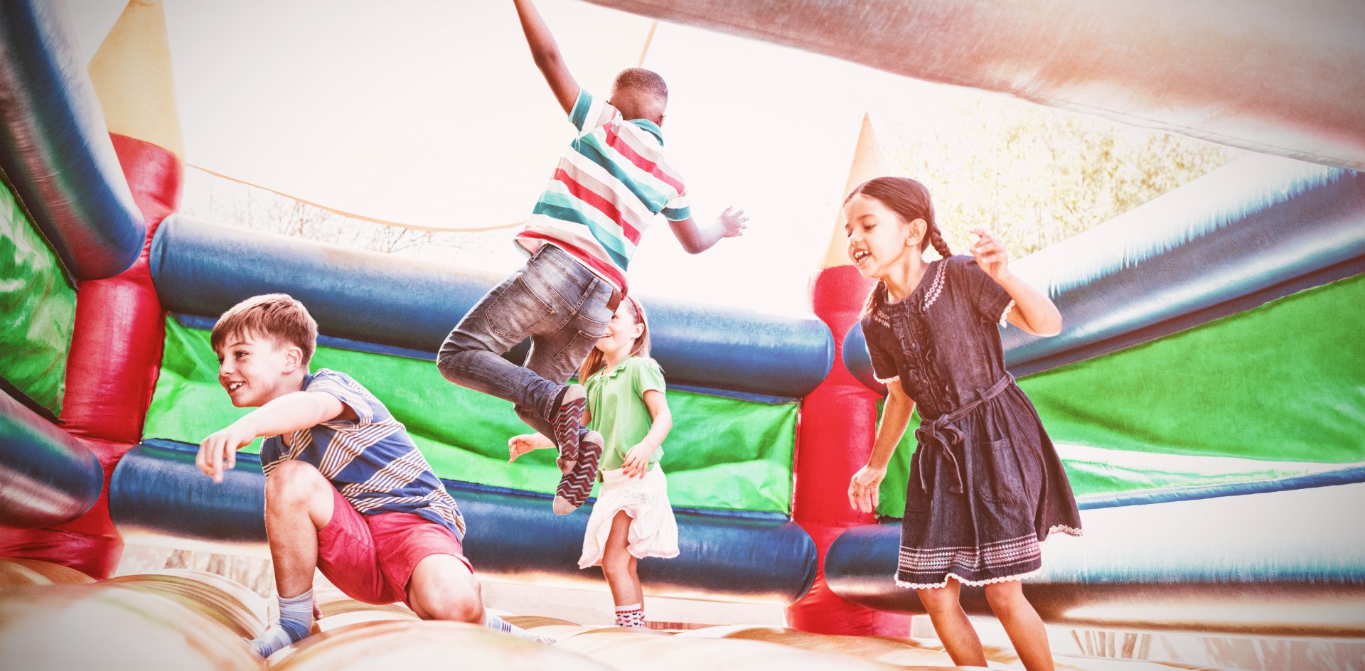 Friends jumping on bouncy castle at playground